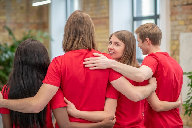 Foto gratuita voluntarios. equipo de jóvenes voluntarios en camiseta roja