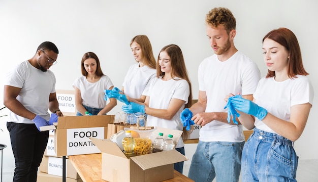 Voluntarios con guantes preparando comida para donación