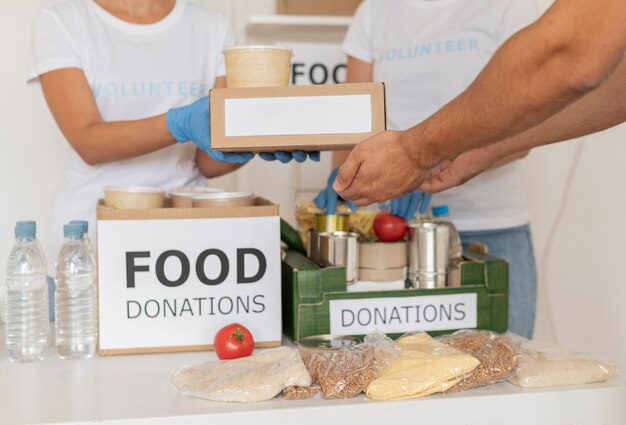 Voluntarios con guantes repartiendo cajas con provisiones para donación