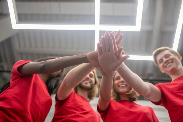 Voluntarios. Jóvenes en camisetas rojas con aspecto alegre y feliz