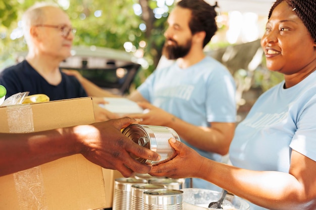 Voluntarios multiétnicos en un evento de caridad, repartiendo comida a los pobres y necesitados. Abundan las sonrisas mientras los individuos voluntarios trabajan juntos para combatir el hambre y proporcionar apoyo a los menos afortunados.