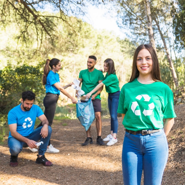 Voluntarios plegable basura en bolsa de plástico en el bosque