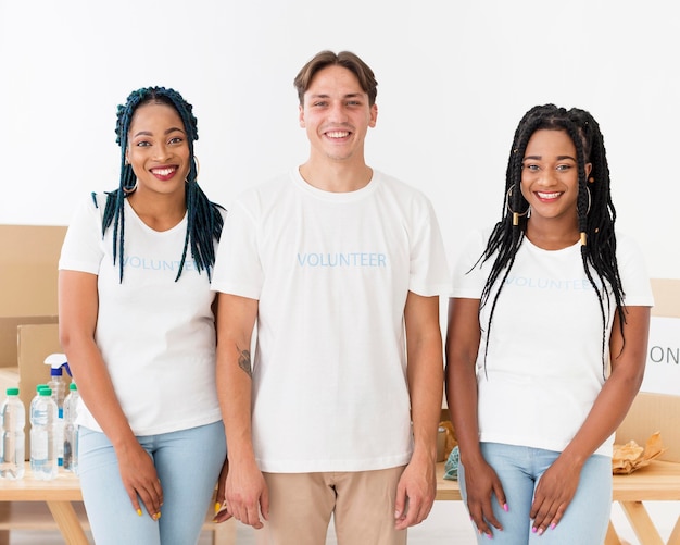 Foto gratuita voluntarios sonrientes posando en el centro de ayuda