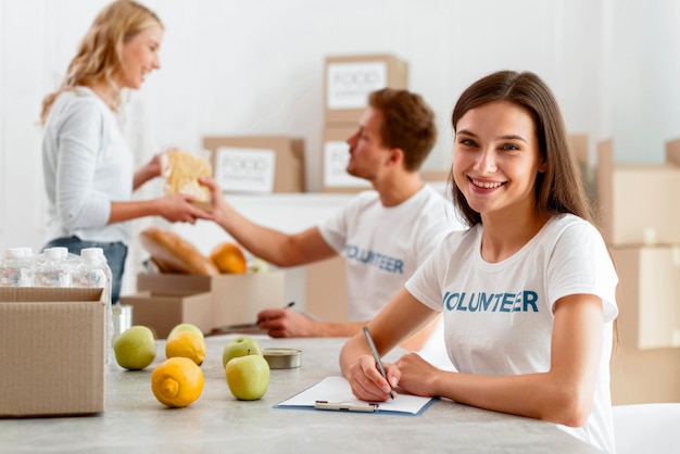 Voluntarios sonrientes que trabajan para donar alimentos