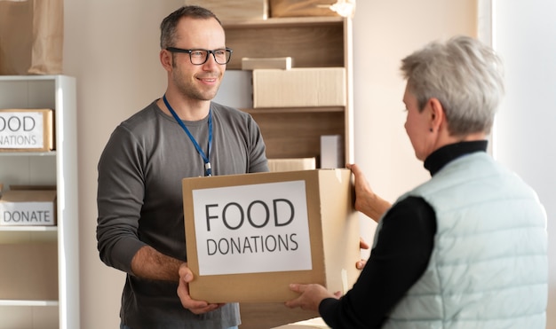 Voluntarios de tiro medio con donaciones de alimentos