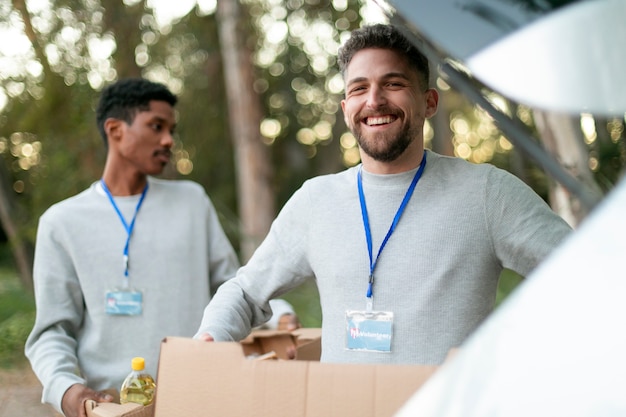 Foto gratuita voluntarios de tiro medio llevando cajas