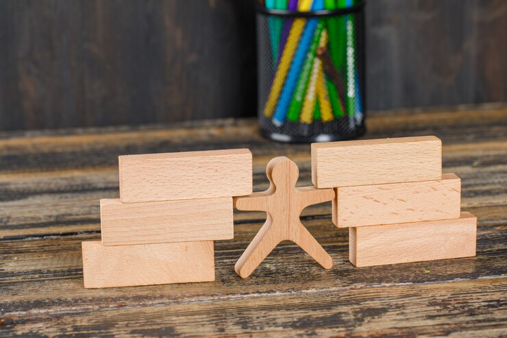 Foto gratuito volver al concepto de escuela con bloques de madera, figura humana, lápices en la mesa de madera vista de ángulo alto.