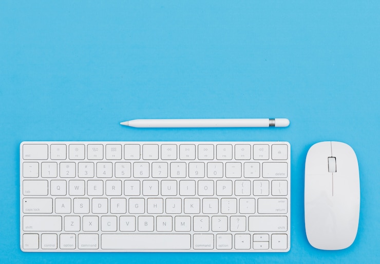 Foto gratuito volver al concepto de escuela con lápiz, teclado, ratón sobre fondo azul plano lay.