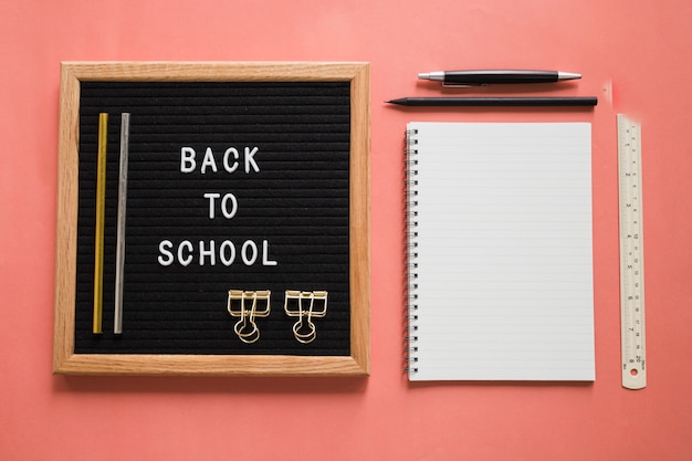 Foto gratuita volver al texto escolar en pizarra con papelería en colores de fondo