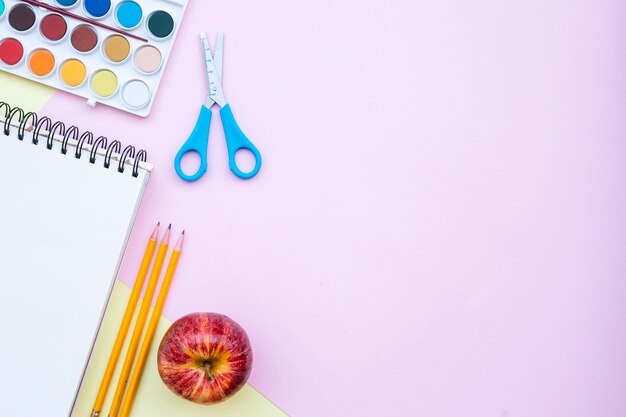 Volver a la composición de la escuela con espacio de copia a la derecha sobre fondo rosa y amarillo