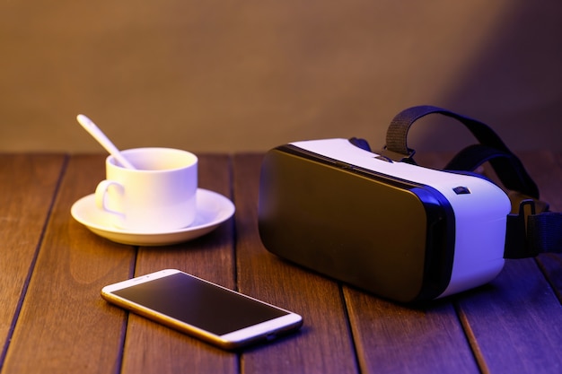 VR gafas y teléfono celular en escritorio de madera