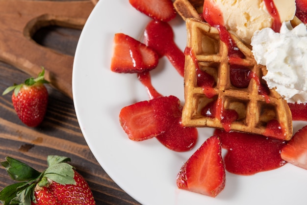 Waffle con fresas, helado de vainilla y crema batida