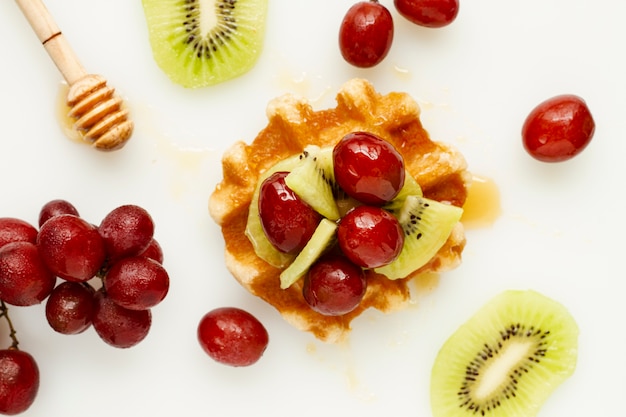 Foto gratuita waffle con miel y mezcla de frutas