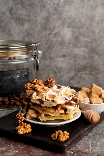 Waffles apilados en un plato con nueces y terrones de azúcar