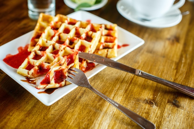 Waffles y café en la mesa de madera