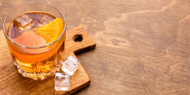 Whisky de alto ángulo y naranja con espacio de copia