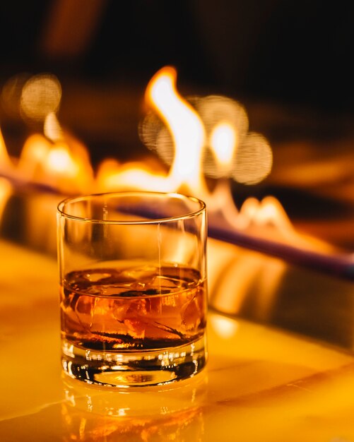 whisky con cubitos de hielo sobre la chimenea