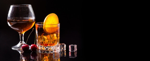 Whisky de vista frontal con copa de coñac y naranja con espacio de copia