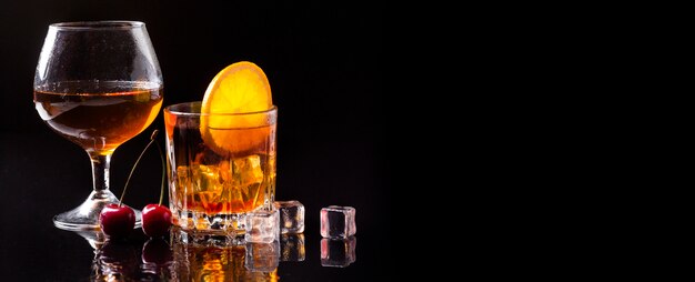 Whisky de vista frontal con copa de coñac y naranja con espacio de copia