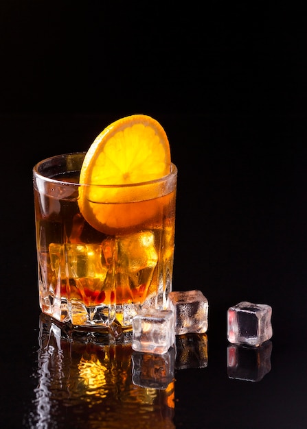 Whisky de vista frontal con naranja y hielo