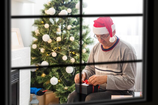 Wiew a través de la ventana, árbol de Navidad en el fondo, concepto de vacaciones de invierno,