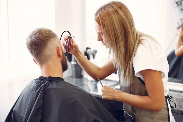 Foto gratuita woma afeitarse la barba del hombre en una barbería