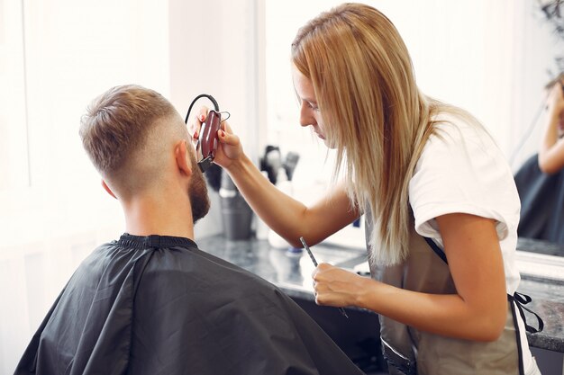 Woma afeitarse la barba del hombre en una barbería