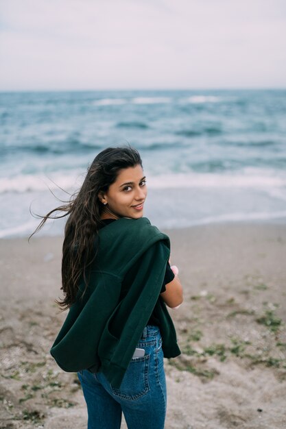 Woma joven dispara en un teléfono inteligente las olas del mar