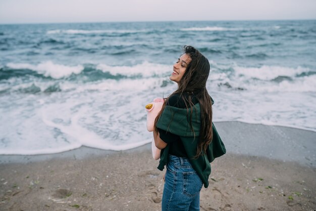 Woma joven dispara en un teléfono inteligente las olas del mar