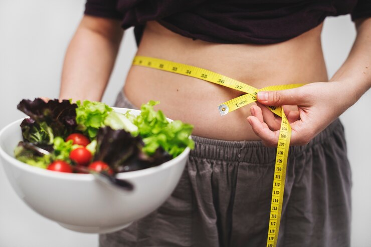 Photo Gratis woman measuring her tummy and weight