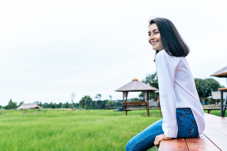 Photo Gratis woman sitting and relax on wood bridge with their legs hanging down