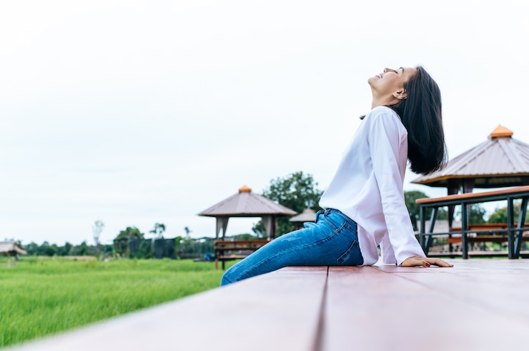 Photo Gratis woman sitting and relax on wood bridge with their legs hanging down