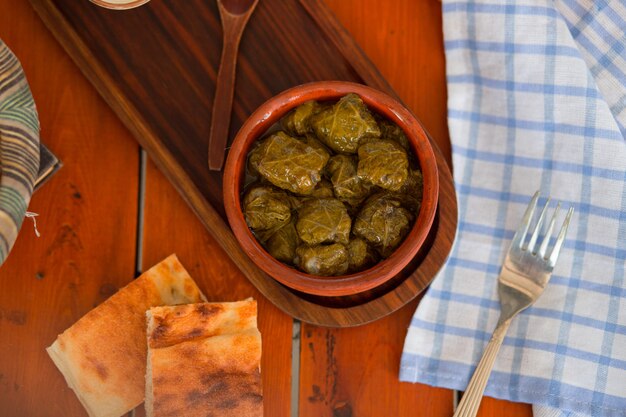 Yarpag dolmasi, yaprak sarmasi, hojas de uva verde rellenas de arroz y carne en un tazón de cerámica.