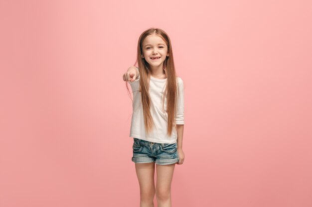 Yo te elijo y orden. La sonriente jovencita apuntando a la cámara, retrato de primer plano de media longitud en rosa