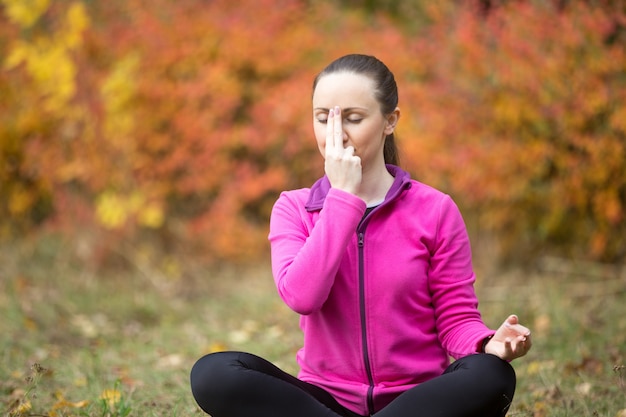 Foto gratuita yoga al aire libre: respiración alternativa de la nariz
