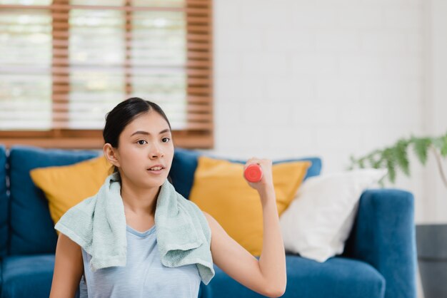 Yoga practicante de la mujer asiática joven en sala de estar.