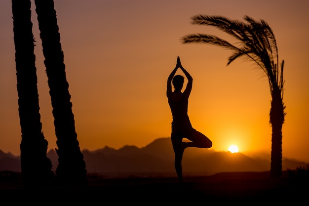 Yoga Vrikshasana postura en la ubicación tropical