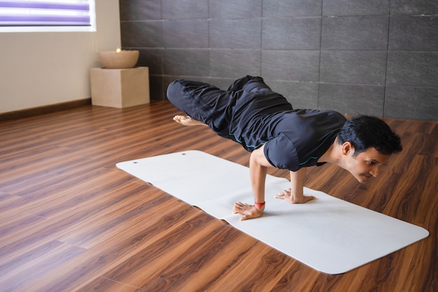 Yogui experimentado haciendo una postura de yoga avanzada de mano