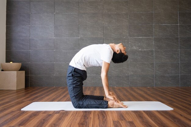 Yogui haciendo yoga camello plantean en el gimnasio