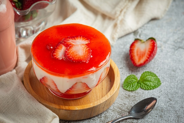 Yogur casero con fresa fresca sobre fondo oscuro antiguo