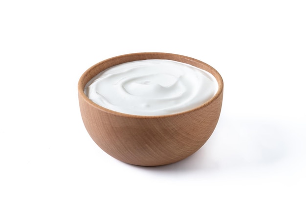 Yogur griego en cuenco de madera aislado sobre fondo blanco.