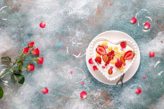 Yogur con hojuelas de maíz y frutos rojos en un tazón con forma de corazón.