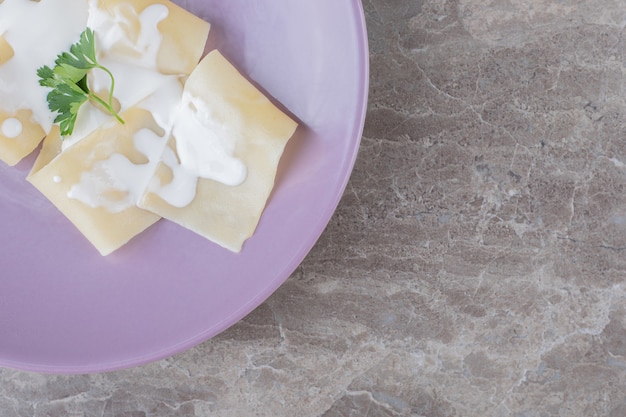 Foto gratuita yogur en láminas de lasaña con verduras en el plato, sobre el mármol.