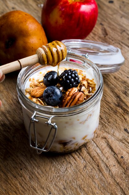 Yogurt de alto ángulo con frutos del bosque negro, nueces y miel