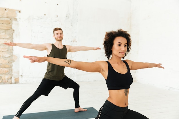 Youg hombre africano y pelirrojo haciendo ejercicios en el gimnasio