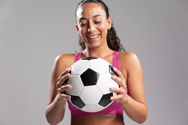 Young fit mujer sosteniendo el balón de fútbol