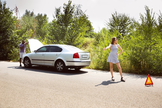 Foto gratuita youngcouple viajando en el coche en un día soleado