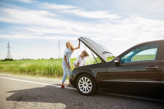 Youngcouple va de viaje de vacaciones en el coche en un día soleado