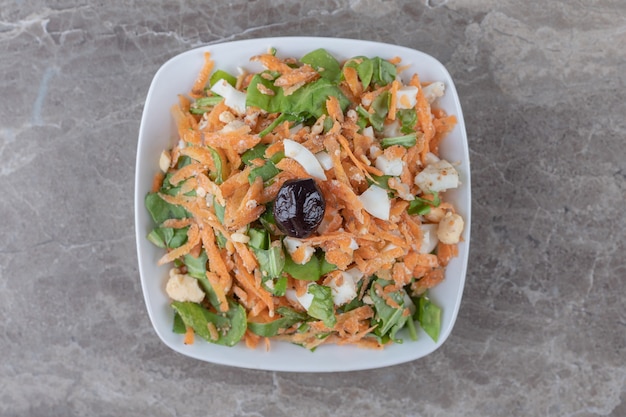 Foto gratuita zanahorias cortadas en cubitos y ensalada de verduras en un tazón blanco.