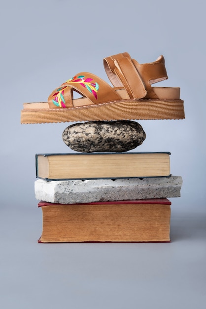 Foto gratuita zapato marrón sobre rocas y libros.